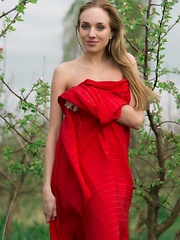 Tayra A playfully posing with a bright red fabric wrapped around her delicate, naked body